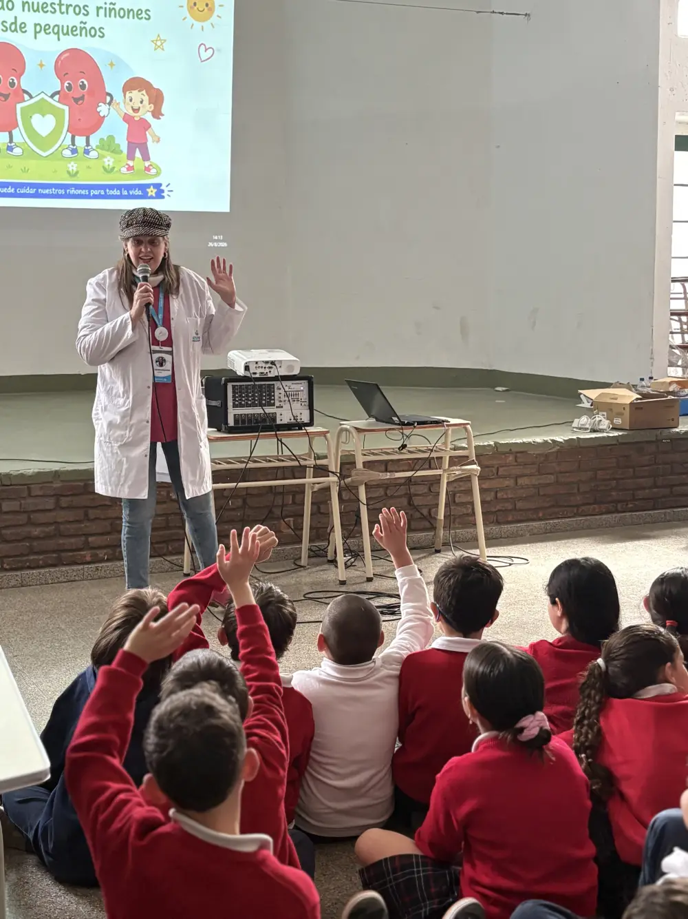 Una profesional de Aterym Alta Gracia da una charla sobre el cuidado de los riñones a niños de primaria, que levantan la mano para participar